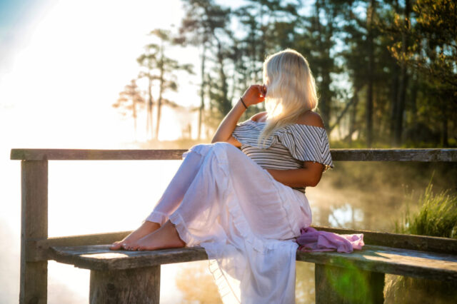 Naise portreefoto puitpingil, rabajärve taust